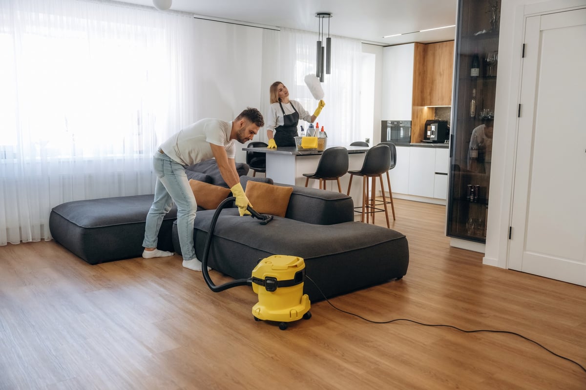 Two GinLau cleaning professionals working together in a bright living room